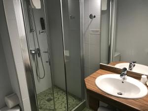 圣让皮耶德波尔拉蒙楚酒店的一间带水槽和玻璃淋浴的浴室