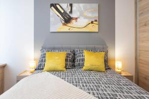 萨格勒布Lux oasis with private parking的一间卧室配有一张带两个黄色枕头的床