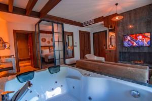 特拉布宗Hayal Vadisi Suite Hotel的带电视的客房内的浴缸