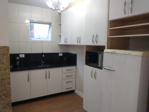 圣若泽杜斯皮尼艾斯Residencial Vitor Studio 5的厨房配有白色橱柜和黑色台面