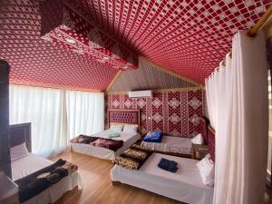 瓦迪拉姆wadi rum land mars的一间设有三张床和红色天花板的客房