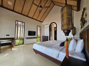 沙美岛Samed Tamarind Beach Resort的一间卧室配有一张床、一张书桌和一台电视