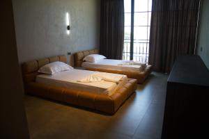RrogozhinëPosh Villas的带窗户的客房内配有两张床和一张沙发