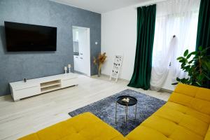 莫伊西德约斯RDT Guest House-Rai din Transilvania的客厅设有黄色沙发和电视