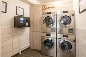 巴黎UCPA SPORT STATION HOSTEL PARIS的洗衣房配有3台洗衣机