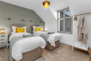 比加Beeswing, a Victorian Gem in Biggar的白色客房的两张床,设有窗户