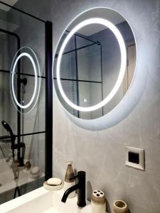 希俄斯Castle luxury home的一间带水槽和大型圆形镜子的浴室