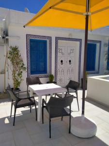 莫纳斯提尔Dar Lilia Monastir的庭院内桌椅和遮阳伞