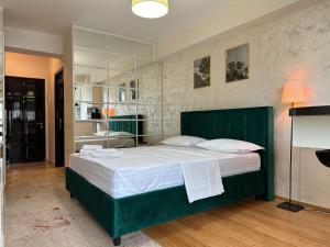 雅西Studios Copou IRO Parhon的一间卧室配有一张带白色床单的大型绿色床。