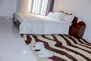 RubavuGreen Safaris Apartment的卧室配有带鞋的地毯床