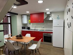 卡索拉佩娜德雷公寓的厨房配有红色橱柜和桌椅