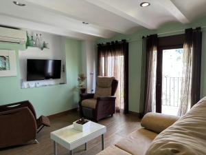 卡索拉佩娜德雷公寓的客厅配有沙发、椅子和电视