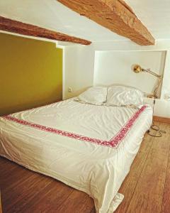 马赛Vaste loft plein de charme au cœur de Marseille的卧室内的一张床位,配有一盏灯,铺有木地板