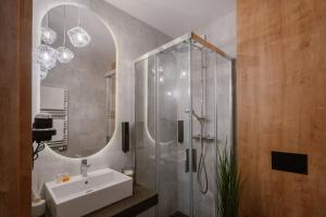 KleosinAPARTHOTEL KLEOSIN的浴室配有盥洗盆和带镜子的淋浴