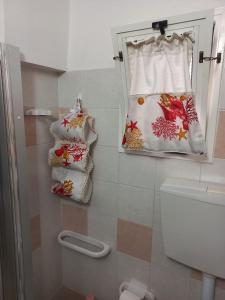 奥里亚Il nido delle aquile的浴室配有卫生间和墙上的枕头。