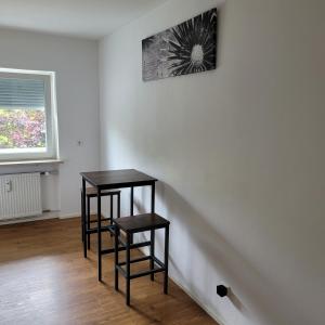 雷根斯堡Schöne, gemütliche möblierte 2 Zi Wohnung in RGB的一间房间,设有两张桌子和一张墙上的照片