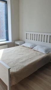 阿斯塔纳Стильная квартира в ЖК бизнес класса AVENUE 5的白色卧室配有一张带白色枕头的大床