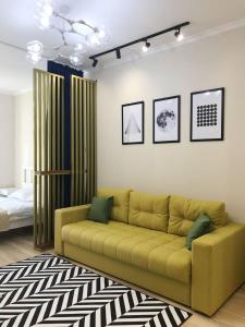 阿斯塔纳Стильная квартира в ЖК бизнес класса AVENUE 5的一间客厅,客厅里设有黄色沙发