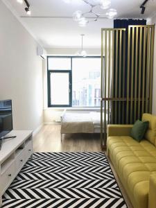 阿斯塔纳Стильная квартира в ЖК бизнес класса AVENUE 5的客厅配有黄色沙发和电视