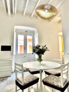 卡洛福泰Tuna House的一张带椅子的白色桌子和花瓶