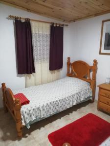 San Juan de la RamblaCasa rustica en Lomo Blanco, dentro de una casa rodeada de naturaleza的一间卧室配有木床和红色地毯。