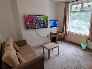 罗奇代尔4 Bedroom House in Central Rochdale cul-de-sac Free Parking & Fast Wi-Fi的带沙发和平面电视的客厅