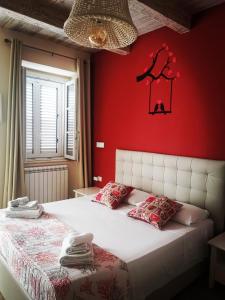 皮佐RESIDENZA MARIA ANTONIETTA - 50 METRI DAL MARE的一间卧室配有一张红色墙壁的床