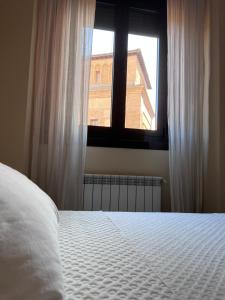 马德里Apartment in monumental square Madrid Center的卧室配有白色的床和窗户。