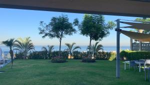朱拜勒德蒙佩尔酒店的享有棕榈树草坪和大海的景色