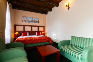 米库洛夫Vivaldi Apartments的一间卧室配有一张床和两张绿色椅子