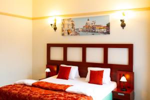 米库洛夫Vivaldi Apartments的配有红色枕头的床的酒店客房