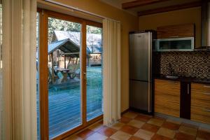 文茨皮尔斯BASH Village House的厨房设有滑动玻璃门,可通往庭院。
