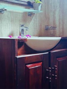 坦加拉AMOUR AT TURTLE BEACH的浴室设有白色水槽,上面有粉红色的鲜花