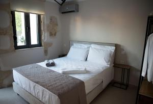 干尼亚Myra city House的一间卧室配有一张带白色床单的床和一扇窗户。