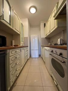 萨格勒布Lanište - Prelijep stan, balkon, wifi + besplatan parking的厨房配有白色冰箱,铺有瓷砖地板。