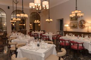 圣克里斯托瓦尔-德拉斯卡萨斯Hotel Plaza 79的餐厅设有白色的桌椅和吊灯。