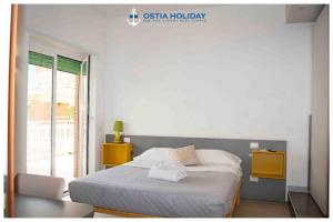 丽都迪奥斯蒂亚Ostia Holiday Sunset的卧室配有床、椅子和窗户。