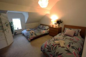 利姆Lymm Village Apartment的一间卧室设有两张床、一盏灯和一扇窗户。