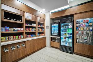 嘉年SpringHill Suites by Marriott Phoenix Goodyear的一间杂货店的过道,里面装有冰箱和饮料