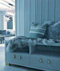 TorsetFjellstova Storehorn Apartments的蓝色沙发,上面有毛绒靠垫和枕头