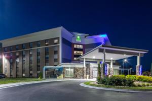 落基山Holiday Inn Express - Rocky Mount - Sports Center, an IHG Hotel的一家晚上设有加油站的酒店大楼