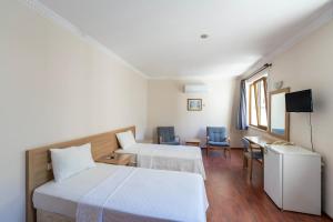 安塔利亚Şehir Hotel的酒店客房带两张床和一张桌子以及椅子。