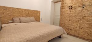 哈尔基斯Stone apartment的一间卧室设有一张床和木墙