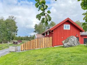 MellösaHoliday home Mellösa IV的前面有栅栏的红色谷仓