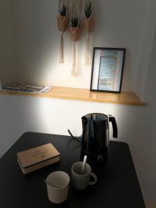 穆兰Appartement cosy Centre ville的咖啡壶和桌子上的两个杯子
