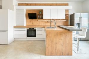 EbenthalWeinlandMotel的厨房配有白色橱柜和木制台面