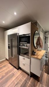 卢恩斯基尔Holiday Home Ljungskile的厨房配有不锈钢冰箱和镜子