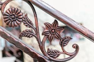 Bughea de SusPensiunea Casa de Vis的一张带鲜花的金属长凳