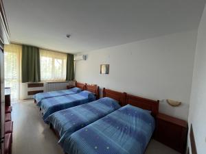 里拉Centaur Family Hotel的配有蓝色枕头的客房内的三张床