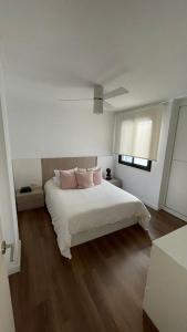 卡耐特蒂贝兰格Atico Canet de Berenguer的卧室配有白色床和粉红色枕头